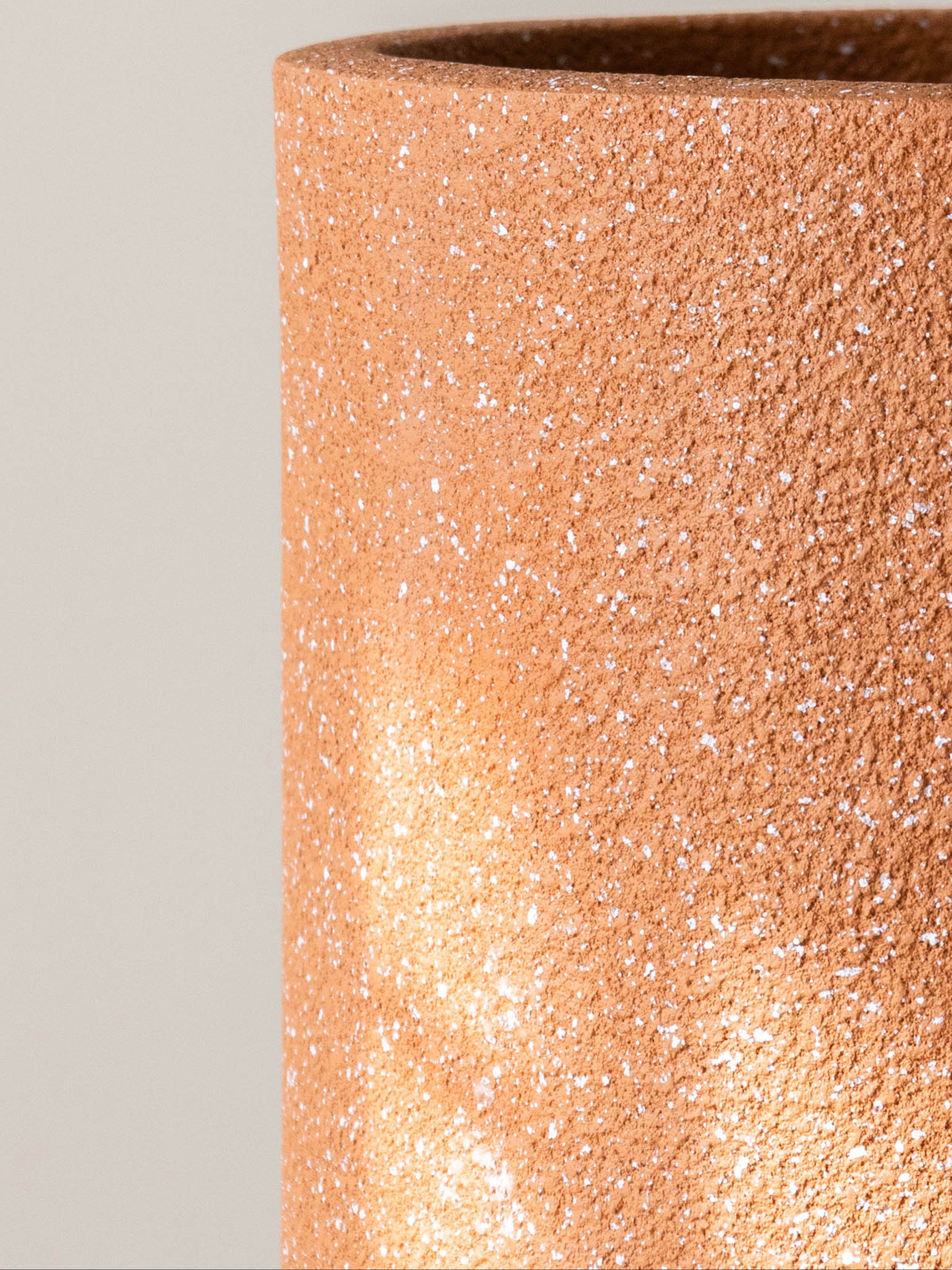 Close-up of a textured brown pot on a light gray background